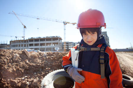 young builder in a red helmet on a background of constructionの写真素材