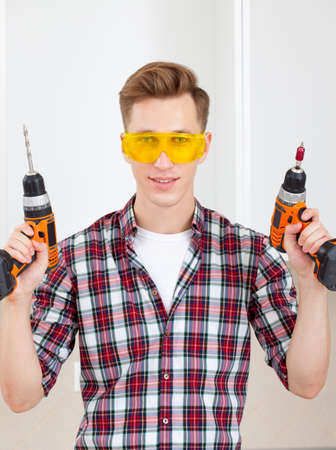 professional repairman with a drill and a screwdriver in his handの写真素材