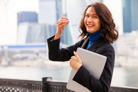 laughing middle-aged woman with a laptop, portraitの写真素材