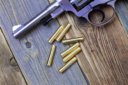 Nagan revolver with cartridges on aged wood background, close-up, part ofの写真素材