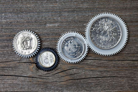 Gears with coins inside on old boardsの写真素材