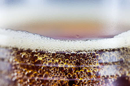 drink with golden bubbles and foam close upの写真素材