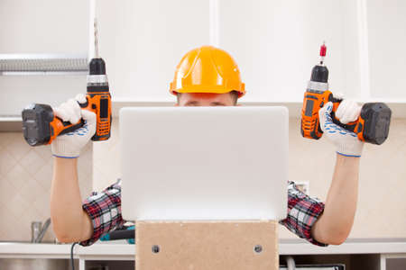 young repairman receives online education in practical skills to repairの写真素材