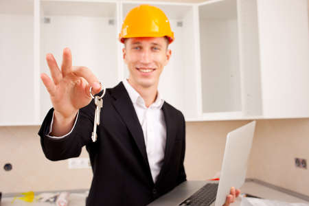 smiling engineer gives keys of new apartmentの写真素材