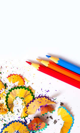 three colored pencils and shavings on white background with copy spaceの写真素材
