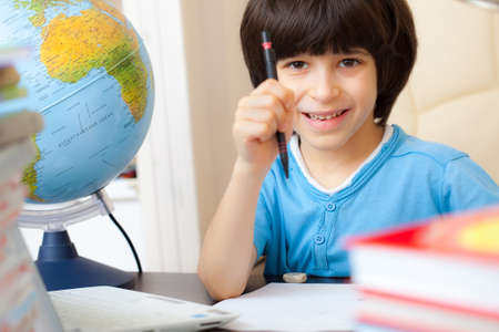 smiling schoolboy doing homework