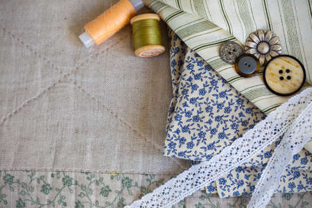 fabric, thread reels, buttons and lace tapes. still life