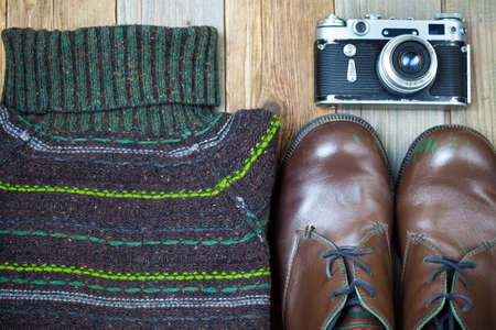 Vintage sweater, shoes, antique rangefinder camera on old rough boards. still life in retro styleの写真素材