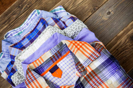 shirts in a stack on a wooden shelfの写真素材