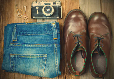 Vintage still life with aged boots, shredded jeans, rusty keys and an old rangefinder camera. image retro styleの写真素材