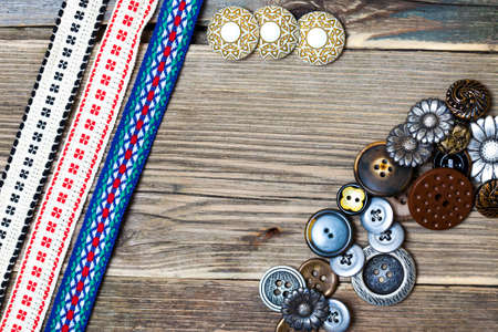 three vintage ribbons, tape and buttons on the old tailoring tableの写真素材