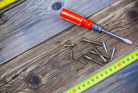 group of screw with a screwdriver on the textured surface of old boards backgroundの写真素材
