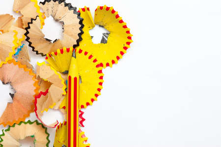 one striped red and yellow pencil and shaving on a white backgroundの写真素材