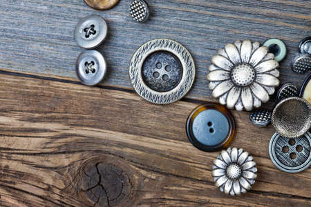several vintage buttons on the aged wooden surfaceの写真素材