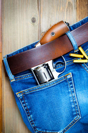 old silver gun and vintage blue jeans with a leather beltの写真素材