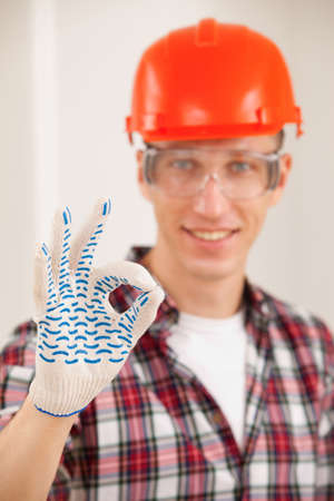 repairman making a perfect gesture with his gloved hand with focus to his handの写真素材