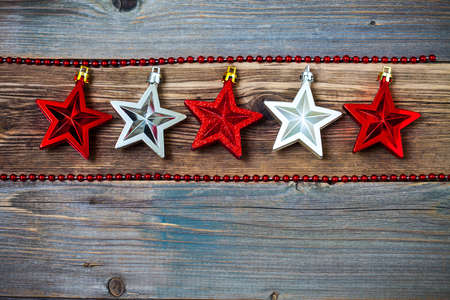 red and silver stars on old textured wooden surface