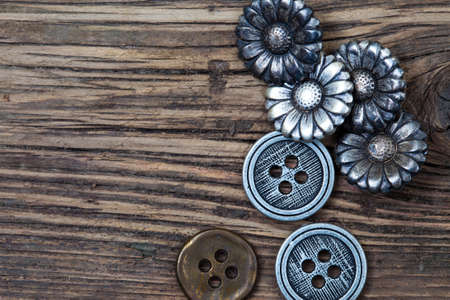 several vintage metal buttons on old textured boardsの写真素材