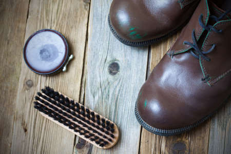 vintage still life with aged brown boots, shoe polish and shoe brushの写真素材