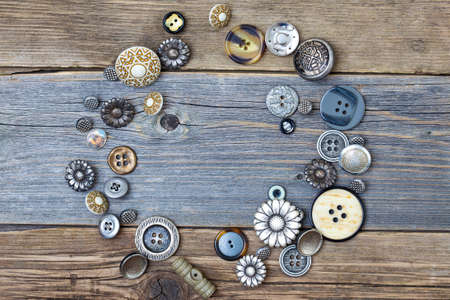 several vintage buttons on the aged table surface with copy spaceの写真素材