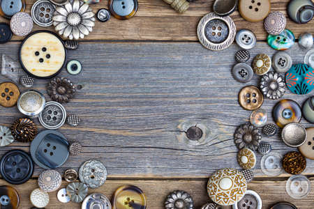 placer of vintage buttons with copy space on textured old boards of aged tableの写真素材