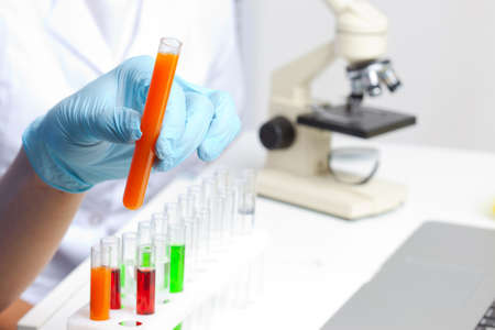 Hand in glove holding test tubeの写真素材