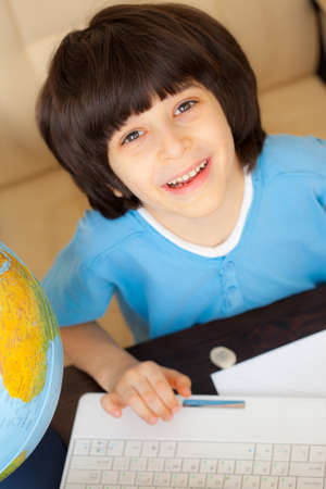 smiling boy doing homework on computer, portrait