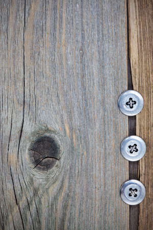 three metal vintage buttons on old textured boardsの写真素材