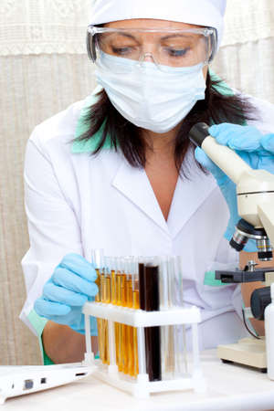 portrait of woman scientist in laboratory analyzing yellow liquid in test tube