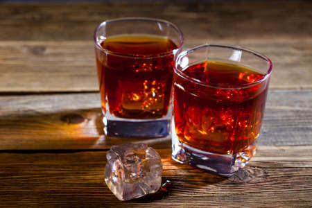 whisky in glasses with ice on the vintage boards in the bar