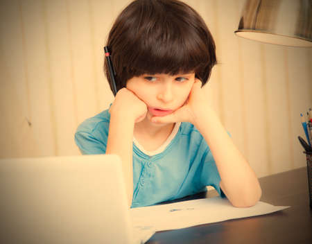 boy looks thoughtfully at the display, portrait 
preschool child. retro style