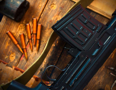 sniper rifle and some ammo on an aged wooden surface. retro styleの写真素材