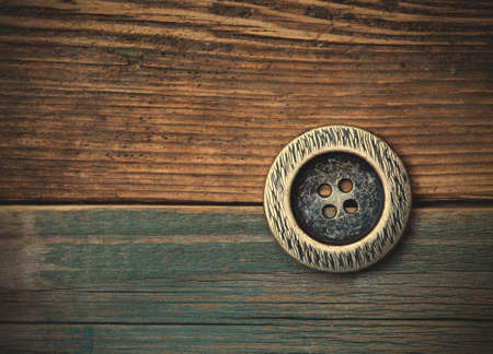 Button for clothes on an old wooden surface of board. instagram image retro styleの写真素材