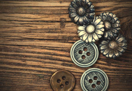 several vintage metal buttons on old textured boards. instagram image retro styleの写真素材