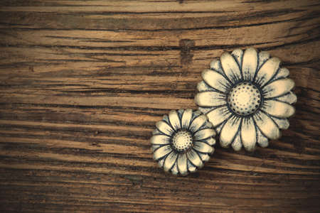 set of two metal vintage buttons in flower image on wooden background. retro styleの写真素材