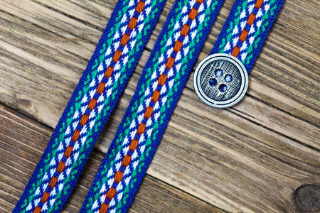 vintage varicolored ribbon with embroidered ornament and old classic button