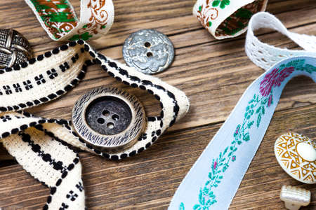 still life with ribbons, lace, tape and buttons on the old tailoring tableの写真素材