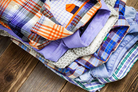 summer bright shirts in a pile on a wooden shelfの写真素材