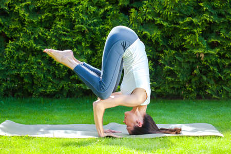 pretty adult woman doing yoga at summer day
