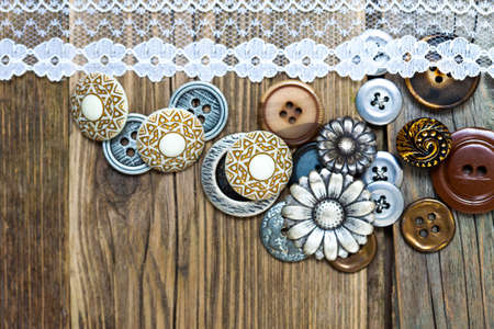vintage buttons and lace tape on old wooden surfaceの写真素材