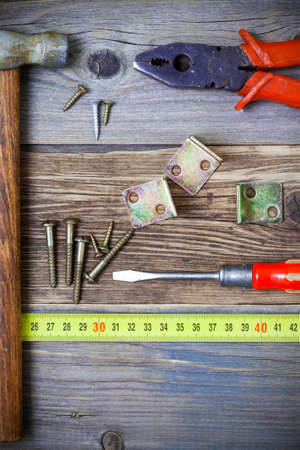 Vintage pliers, screwdriver, screws, hammer, angles and roulette. Still life with old tools