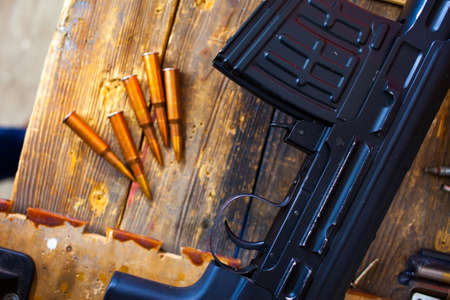 sniper rifle and several cartridges on vintage wooden surfaceの写真素材