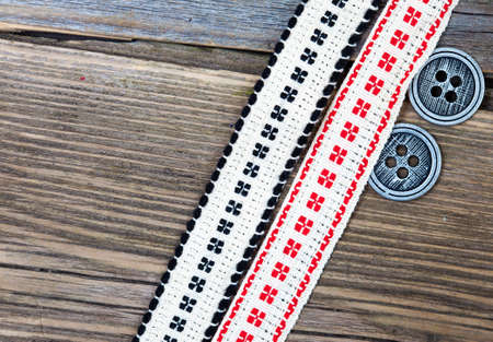 old band with embroidered ornaments and vintage buttons on a textured surface aged boards