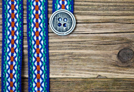 still life, vintage varicolored ribbon with embroidered ornament and old classic button