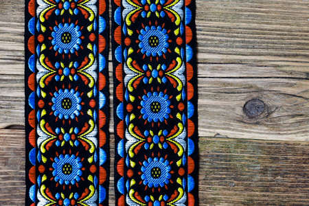 vintage varicolored tape with embroidered ornament on old boards