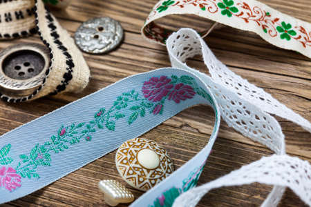 vintage ribbons, lace, tape and buttons on the old tailoring tableの写真素材