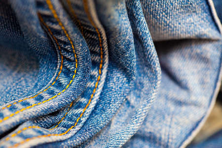 aged Jeans with yellow stitching thread, close up. small depth sharpness