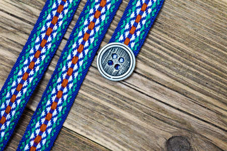still life, vintage varicolored band with embroidered ornament and old classic buttonの写真素材