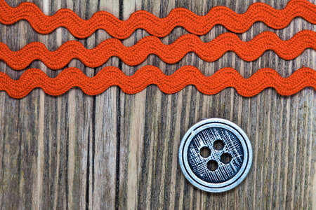 vintage button and old three red tape on a textured surface aged boards