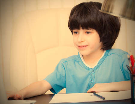 boy doing homework with computer, portrait.の写真素材